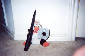 The Penguin threatens a scrunchie with a knife.