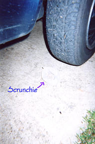 A scrunchie about to be squashed by a tire.